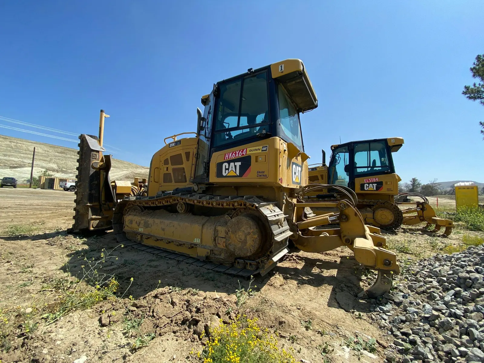 Two Cat dozers with rear rippers on a gravel job site