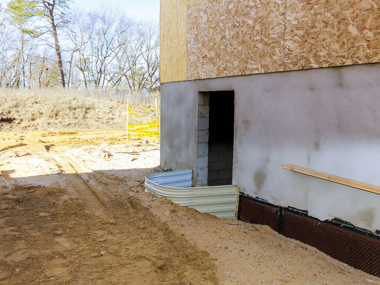 Poured foundation wall with a basement window opening on a new home build site
