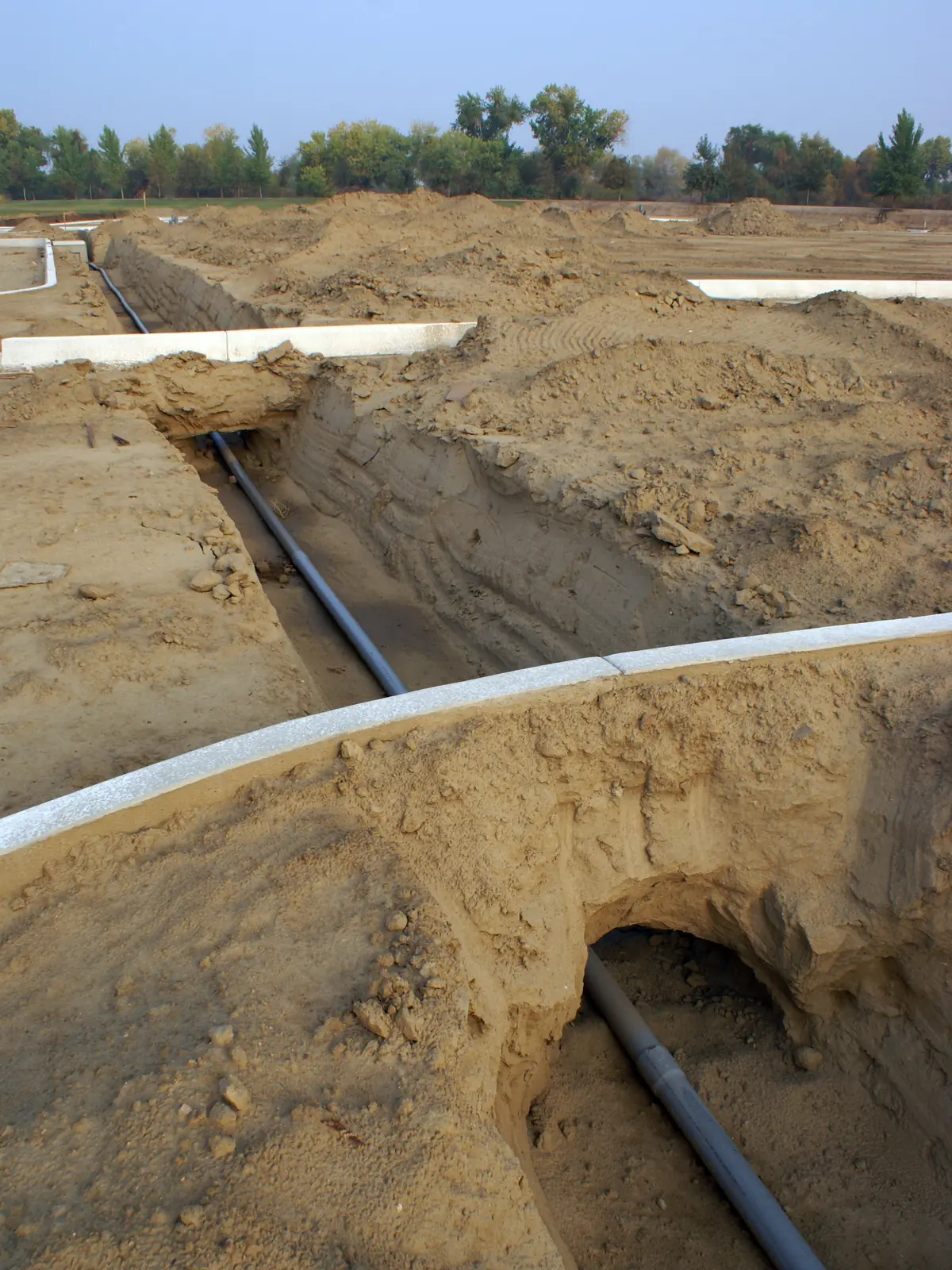 Water line pipe laid in the bottom of an open trench before backfill